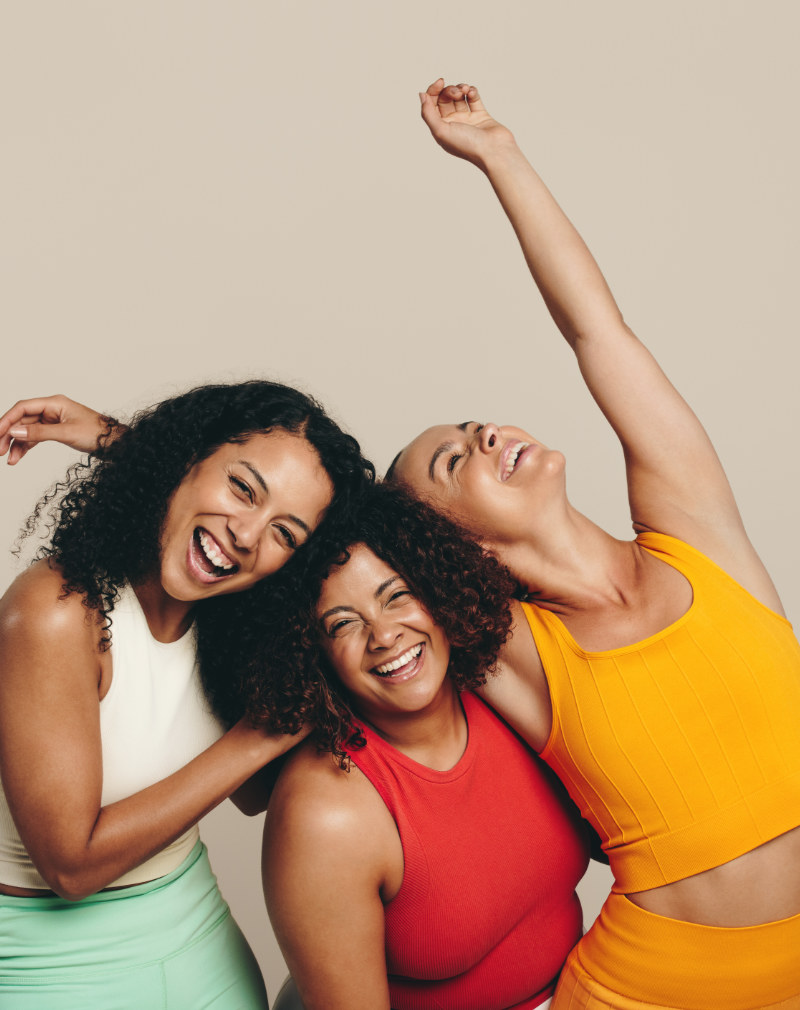 Celebrating Sport And Fitness: Three Young Women Standing In A Studio Wearing Fitness Clothing